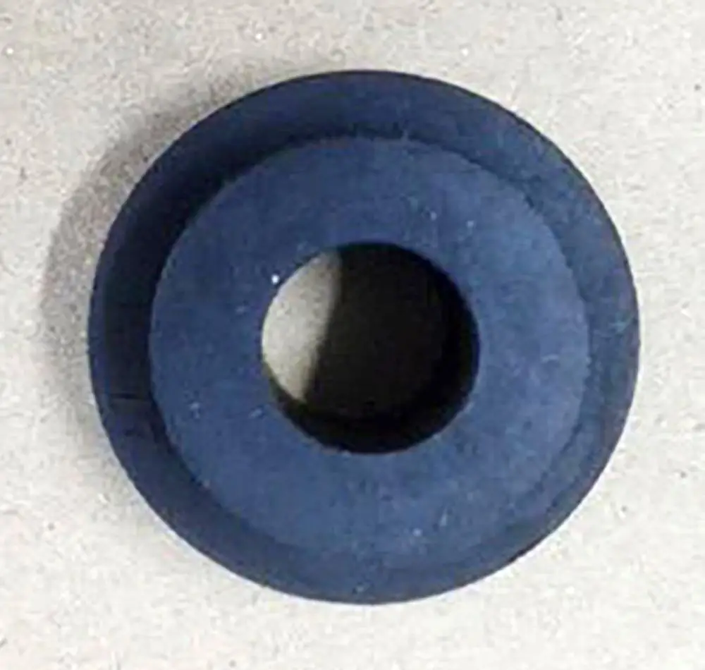 Gummiteil in dunkler Farbe mit zentralem Loch, als Federhalter für Daikin Produkte verwendet. Flache Oberfläche und rundes Design, geeignet für spezifische Anwendungen.